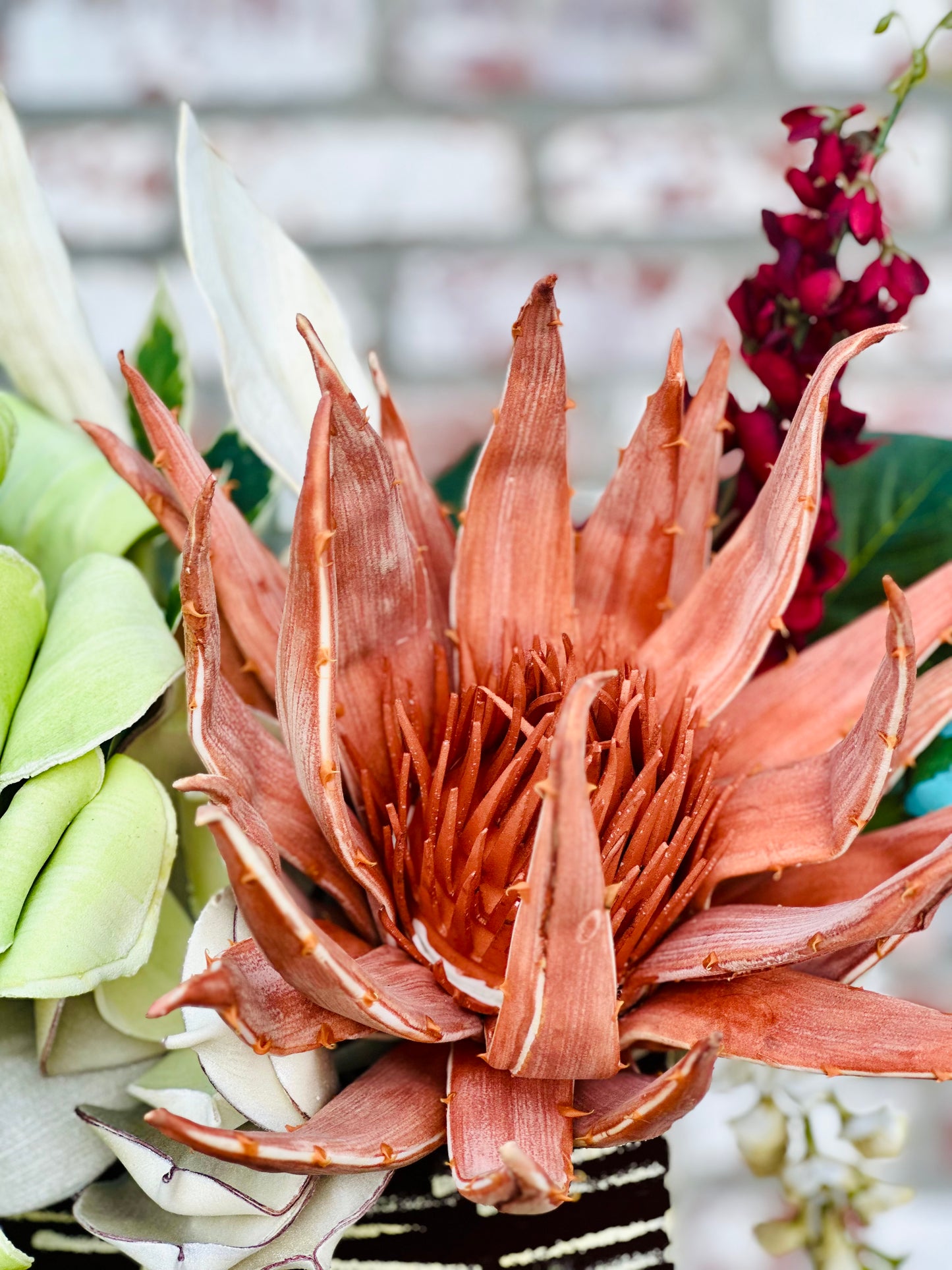 Floral Arrangement – Teal & Terracotta Centerpiece with Sculptural Green Foliage in Textured Planter