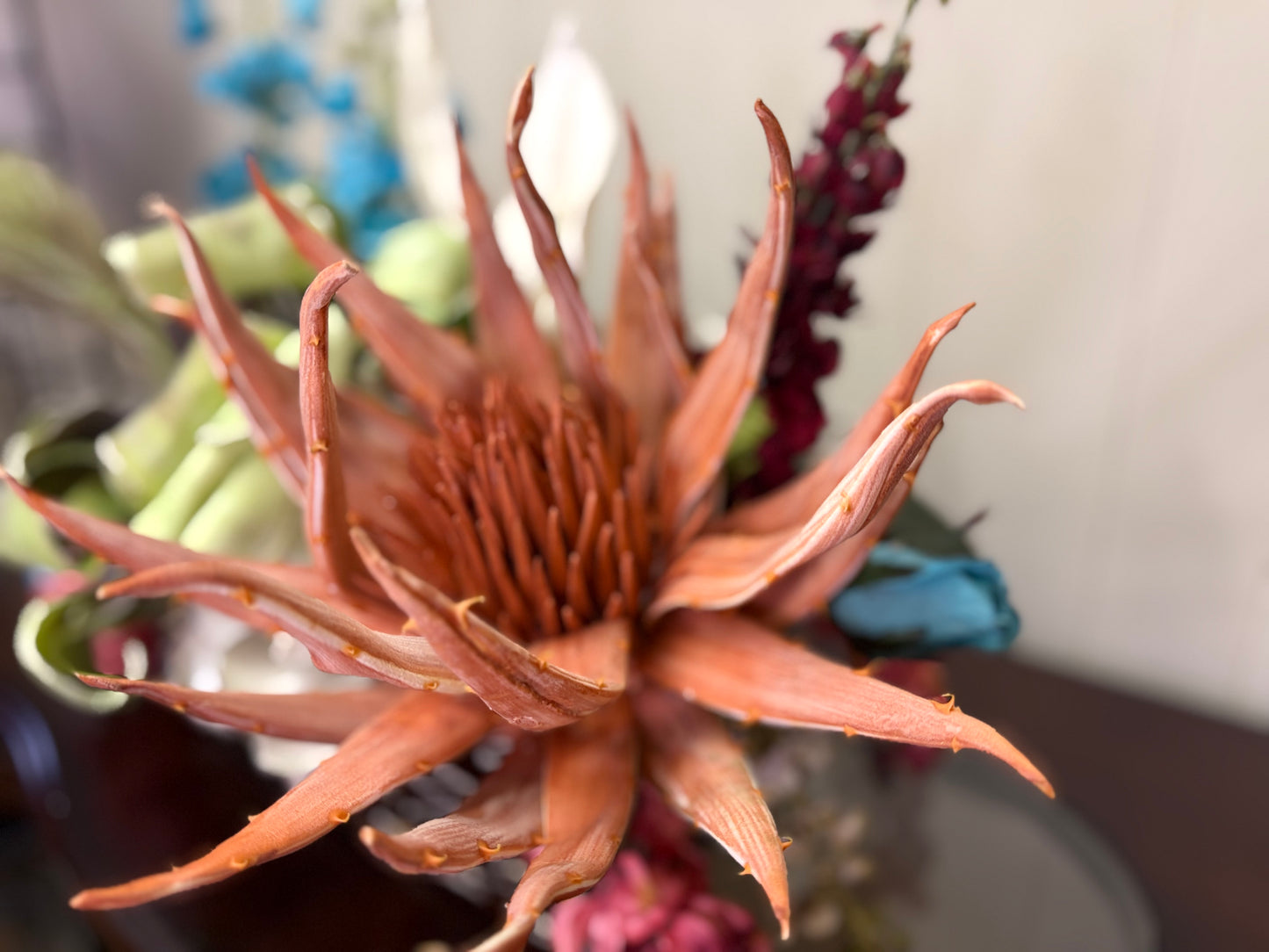 Floral Arrangement – Teal & Terracotta Centerpiece with Sculptural Green Foliage in Textured Planter